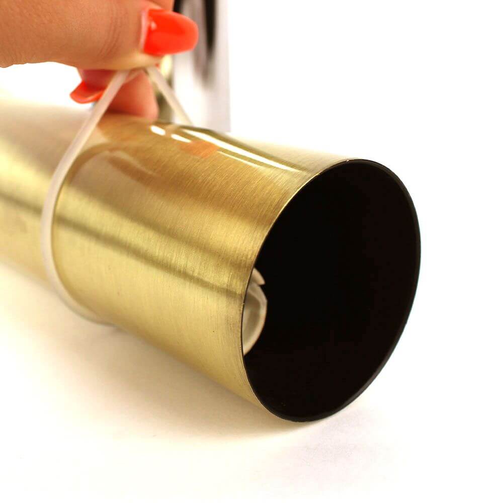 Gummiringe für s.luce Crutch Hängeleuchte in der Hand, goldener Lampenschirm mit schwarzem Inneren.