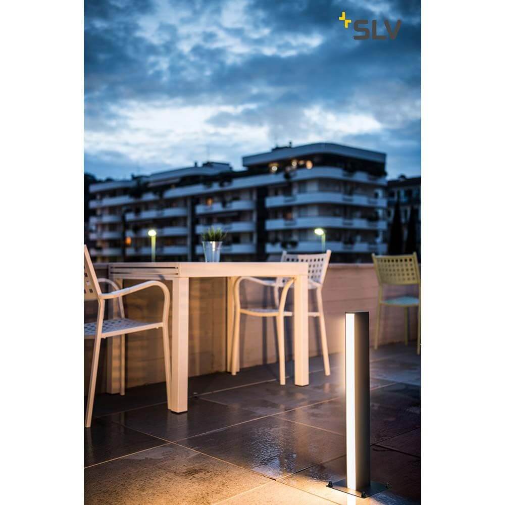 H-Pol Wege- & Standleuchte Einflammig LED 3000K Anthrazit 66cm neben einem Tisch auf einer Terrasse.