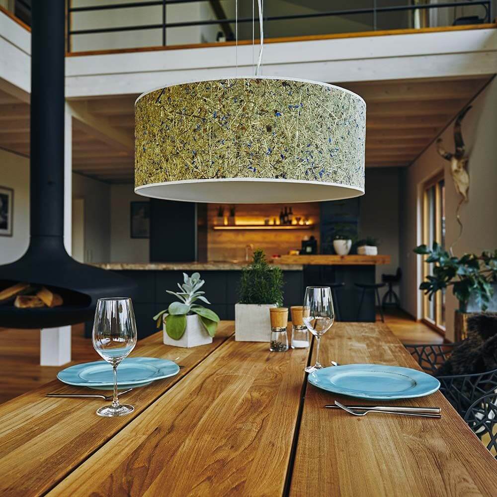 Hängelampe Discus mit Diffuser Almheu über einem Esstisch, mit blauem Geschirr und stilvollem Interieur.