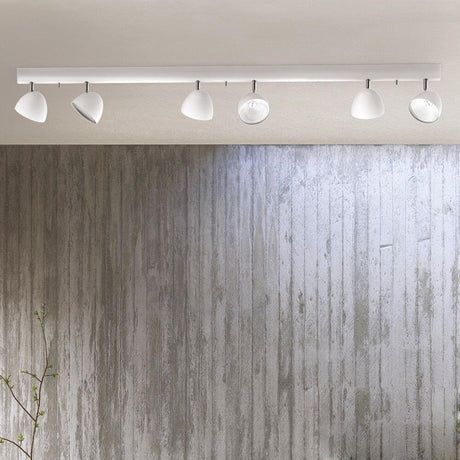 Headlight 6er Strahlerschiene 150cm Weiß mit symmetrischer Anordnung der Strahler an einer Wand.