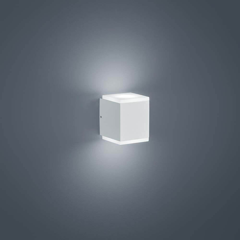LED Wandaussenleuchte Kibo IP54 Weiß an einer grauen Wand, stilvolles Design und warmes Licht.