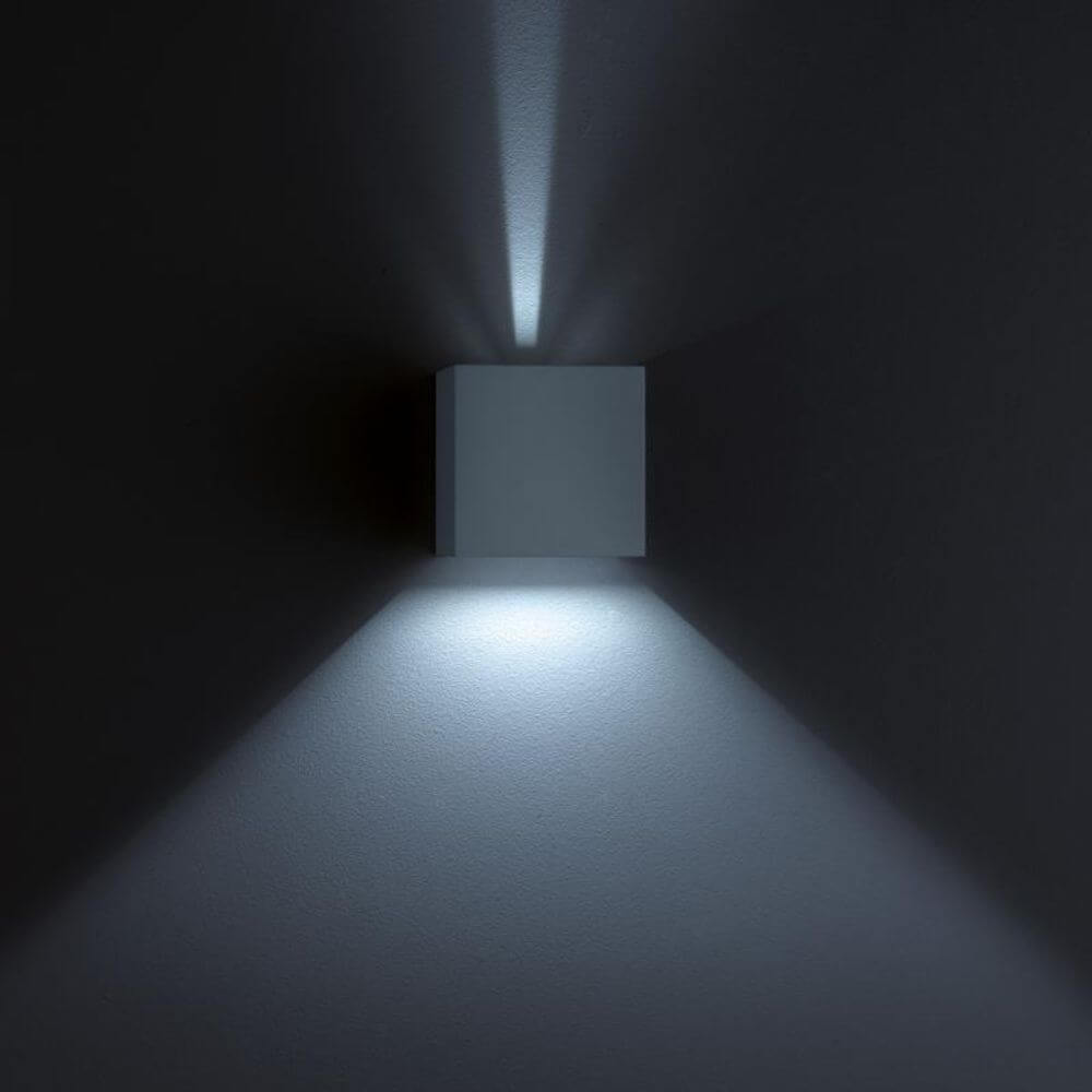LED Wandaussenleuchte Siri 44 IP54 Schwarz an einer Wand montiert mit sanftem Lichtschein.