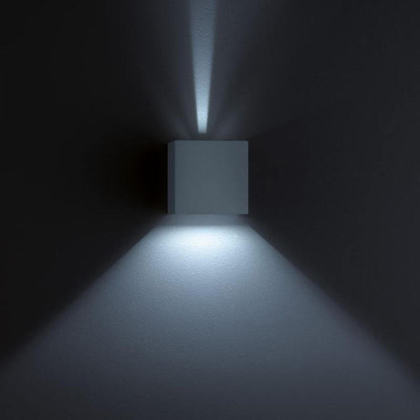 LED Wandaussenleuchte Siri 44 IP54 Schwarz an einer Wand montiert mit sanftem Lichtschein.