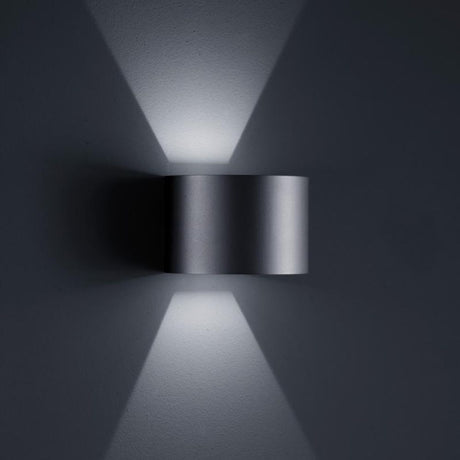 LED Siri 44 outdoor wall light - R IP54 black on a grey wall with soft beams of light.