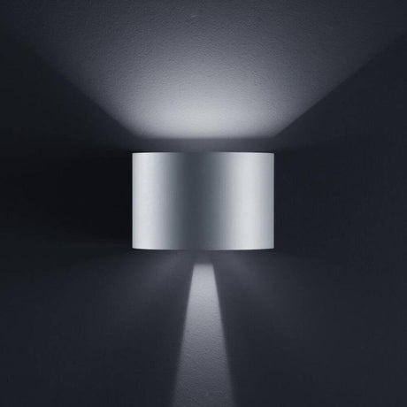 LED Außen-Wandleuchte Siri 44 - R IP54 Silbergrau an einer Wand mit sanfter Beleuchtung.
