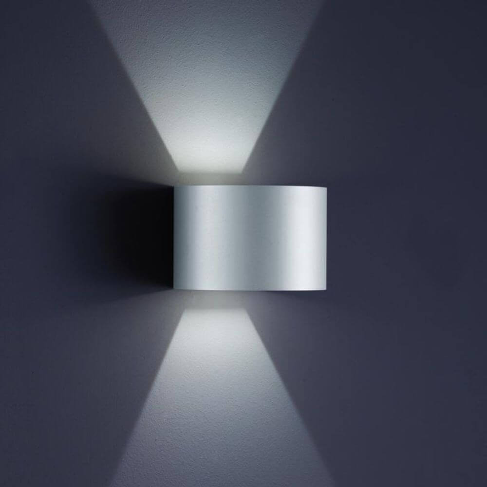 LED Außen-Wandleuchte Siri 44 - R IP54 Silbergrau an einer Wand montiert, mit sanften Lichtstrahlen.