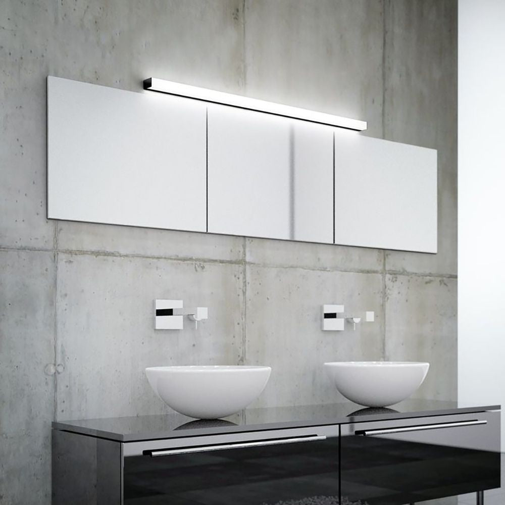 Moderne Spiegelleuchte Lado 120cm über zwei eleganten Waschbecken in stilvollem Badezimmer mit grauer Wand.