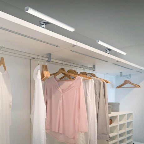 LED Gaia krom væglampe i moderne garderobe med træbøjler.