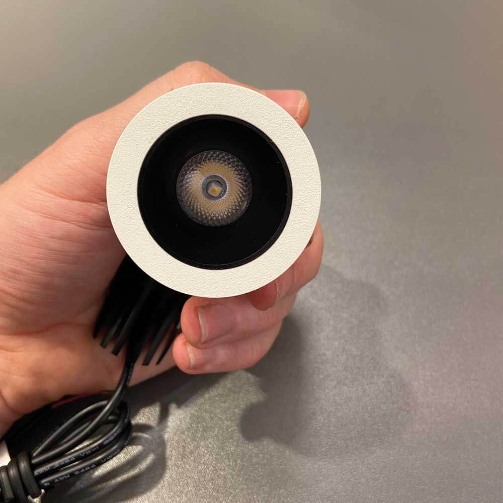 Mini LED Decken-Einbauleuchte Pic mit Zylinder in Hand gehalten, weißes Design mit mattem Finish.
