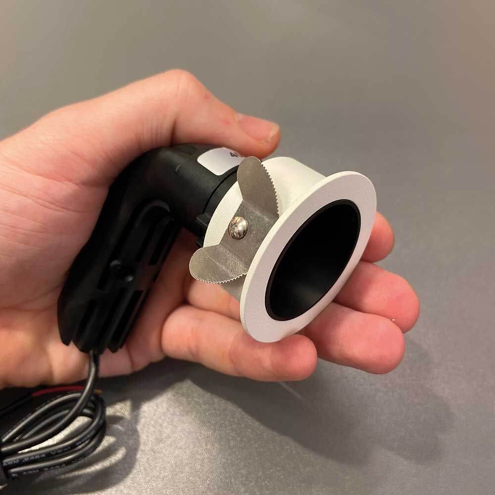 Hand hält Mini LED Einbaustrahler Pic mit weißem Rahmen und schwarzer Innenseite für moderne Innenräume.