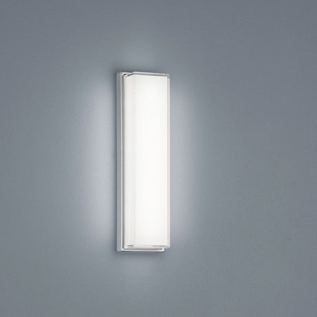 LED-vegglampe Cosi krom på en grå vegg, ideell for individuell belysning i badområdet.