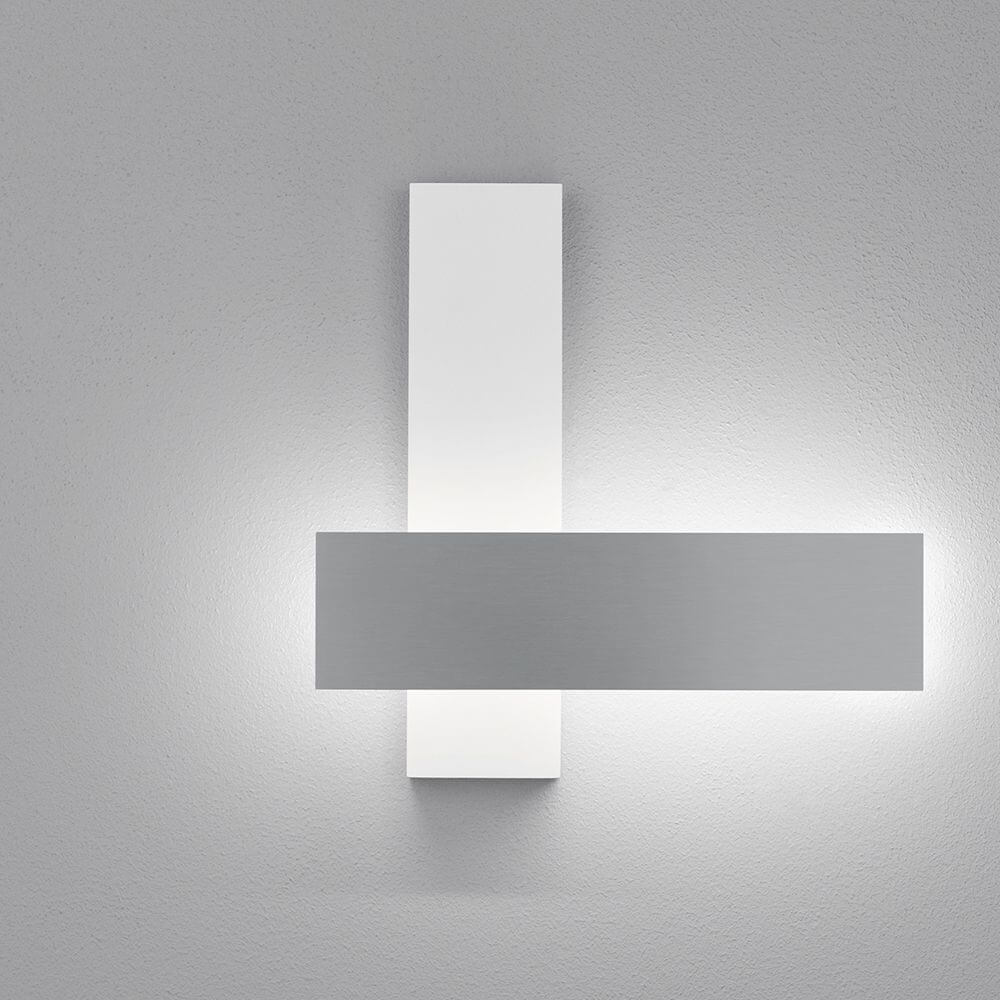 LED Wandleuchte Dex Weiß, Alu-Poliert an einer grauen Wand, modernes Design mit dimmbarer Funktion.
