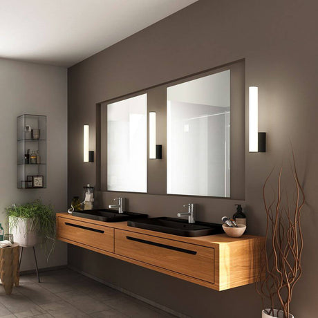 Wandleuchte Loom IP44 Schwarz im modernen Badezimmer mit zwei Waschbecken und großen Spiegeln.