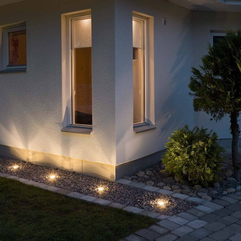 Helles Licht von High Power LED Bodeneinbaustrahler, klares Glas an der Außenwand eines Hauses.