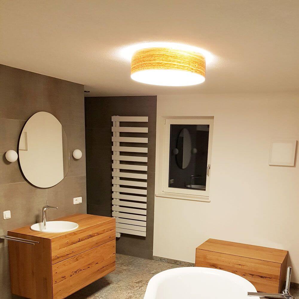 Holz-Deckenleuchte Discus Deutsche Eiche in modernem Badezimmer mit warmem Licht.