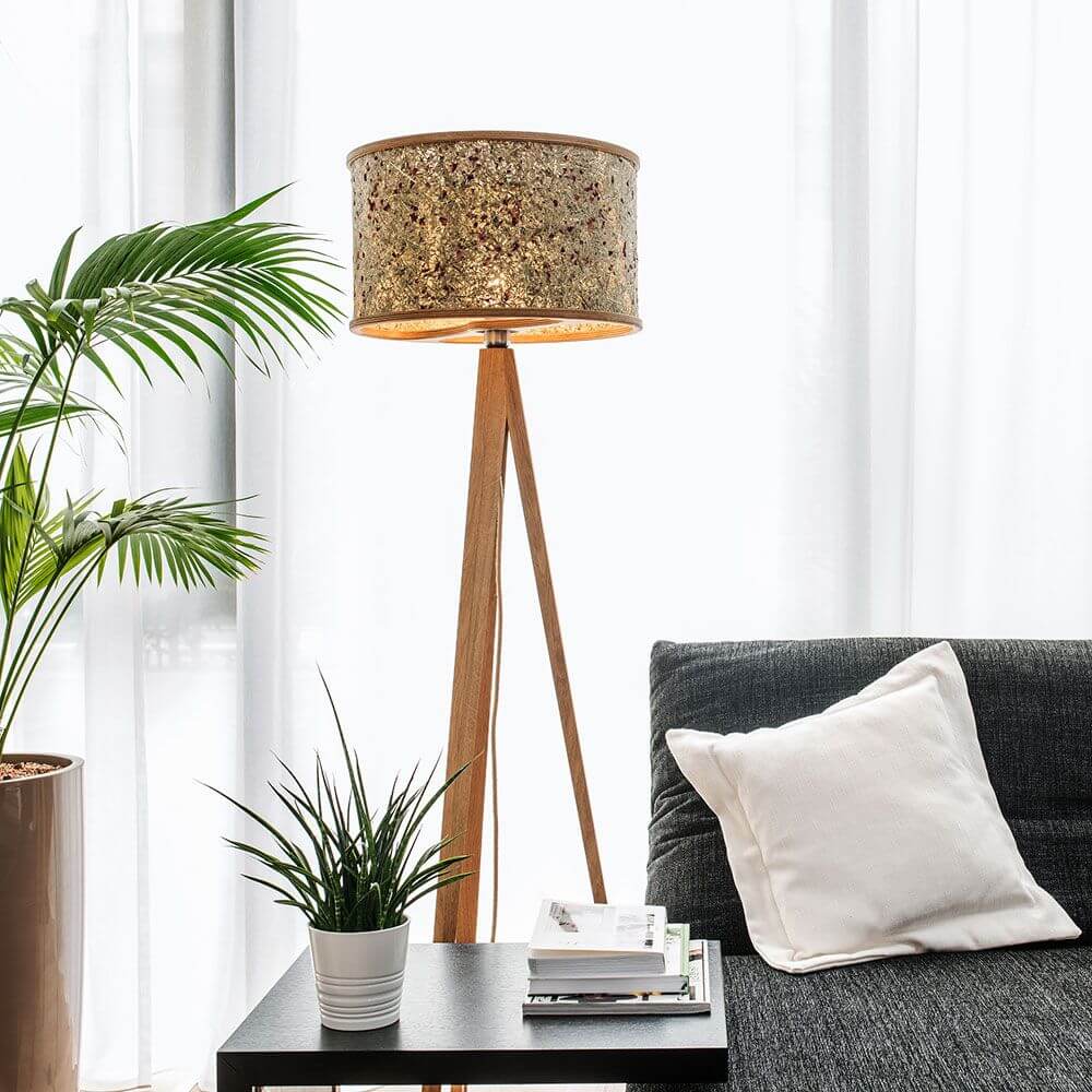 Holz Stehlampe 163cm mit Heuschirm neben einem Sofa in einem modernen Wohnraum.