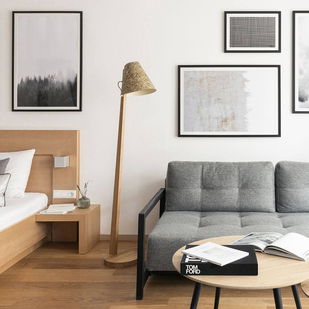 Holz Stehleuchte mit Schirm geschwungen 167cm in modernem Wohnzimmer mit Couch und Bildern an der Wand