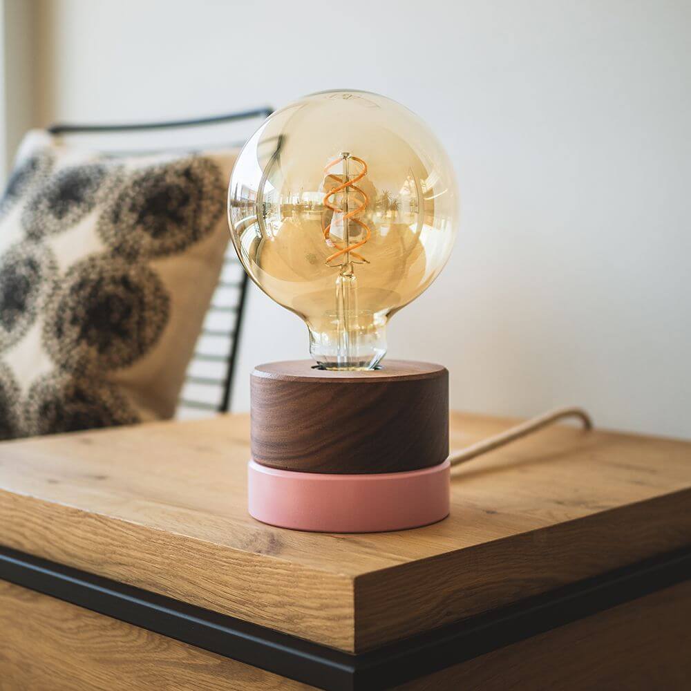 Holz Tischlampe Ø 11cm in 3 Holzarten mit runder Glühbirne und minimalistischem pinken Sockel.
