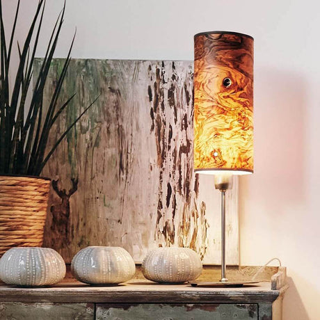 Holz-Tischlampe Arboreus 50cm Olivesche-Maser auf einem Sideboard mit Pflanzen und Deko-Elementen.