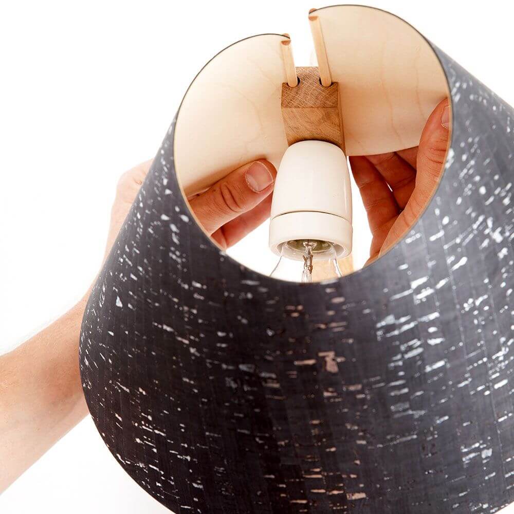 Detailaufnahme der Holz Tischleuchte mit Schirm geschwungen, montiert mit einer schwarzen Kork-Lampenschirm.