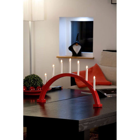 Holzleuchter rot lackiert 7 klare Birnen Innen auf einem Tisch in modernem Wohnraum.