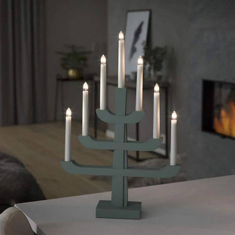 Holzleuchter grün grau lackiert 7 klare Birnen auf einem Tisch in modernem Wohnraum.