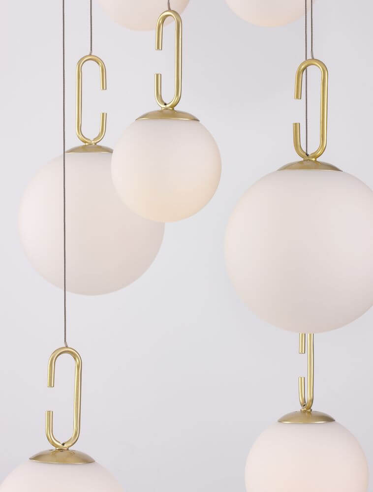 Hook LED Pendelleuchte 7-flammig Ø 56,6cm 3000K Gold-Gebürstet, Weiß mit weißen Glaskugeln und goldenen Haken.