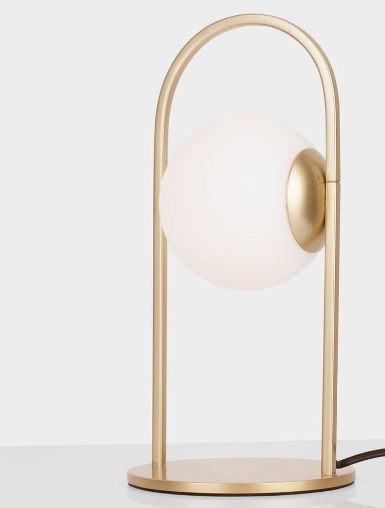 Hook LED Tischleuchte 3000K Gold-Gebürstet, Weiß auf einem Tisch, modernes Design mit Glas- und Metallelementen.