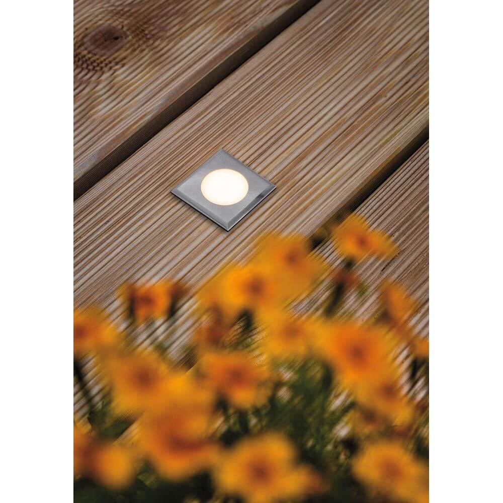 House LED Bodeneinbauleuchte Eckig Edelstahl IP67 auf Holzdeck mit blühenden Blumen im Vordergrund.