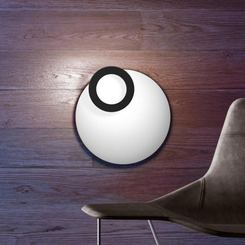 Icone LED Deckenleuchte Vera Ø 66cm in Weiß und Schwarz an Holzwand, moderne Wohnraumbeleuchtung.