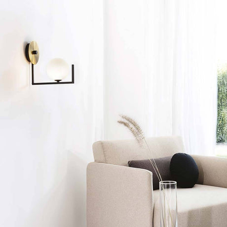 Birds Wandleuchte in modernem Wohnraum mit goldener Wandhalterung und opaler Kugellampe