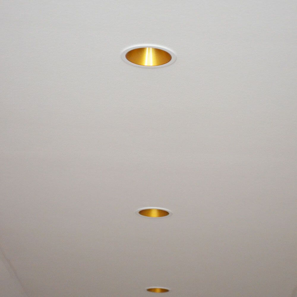 LED Einbaustrahler Game Round Weiß, Gold in einer Decke mit mattem Goldring.