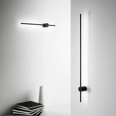 Essence LED wall light in a modern design, in the background a black-and-white room with minimalist decor.