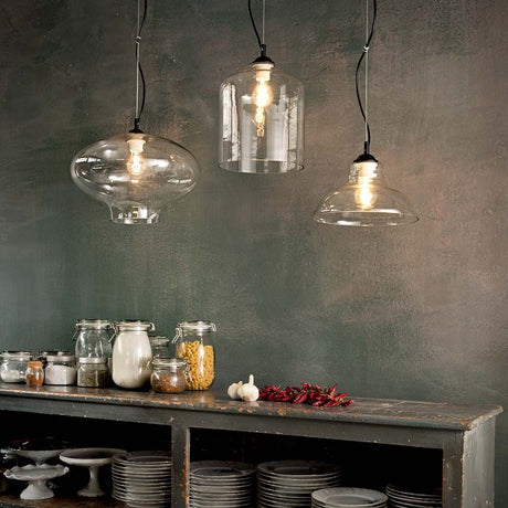 Bistro SP1 Plate Transparent pendant light in a stylish room with glass bodies and a wooden shelf.