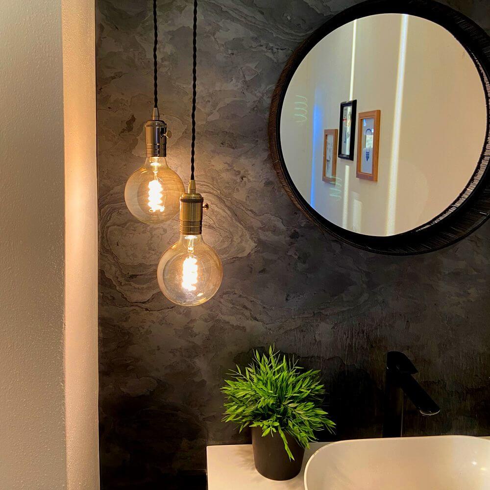 Hängeleuchte Doc Sp1 Retro Kupfer-Antik mit schwarzen Kabeln in modernem Badezimmer-Design.