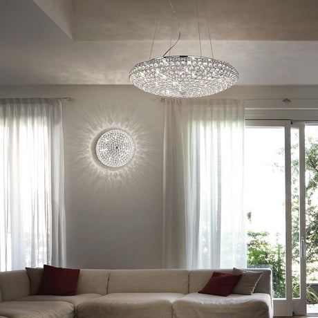 Hängeleuchte King Sp12 Chrom über dem Sofa im Wohnzimmer mit Vorhängen und Tageslicht.