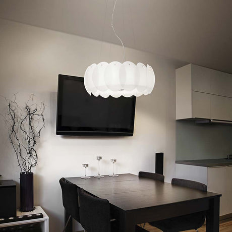 Hängeleuchte Ovalino Sp8 in modernem Essbereich mit schwarzem Tisch und Fernseher im Hintergrund.