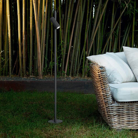 Hub Außen-Stehleuchte IP54 neben einem gemütlichen Sessel im Garten.