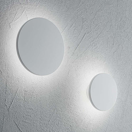 LED Wandleuchte Cover Rund Klein Weiß an der Wand, zwei runde, weiße Leuchten strahlen warmes Licht aus.