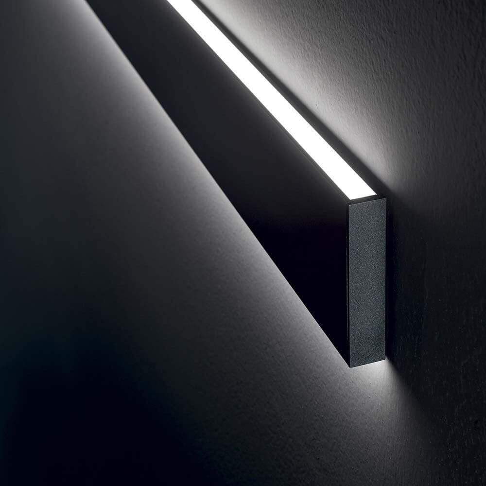 Linus LED Wandleuchte 120cm an der Wand, modernes Design mit warmem Licht, ideal für stilvolle Beleuchtung.