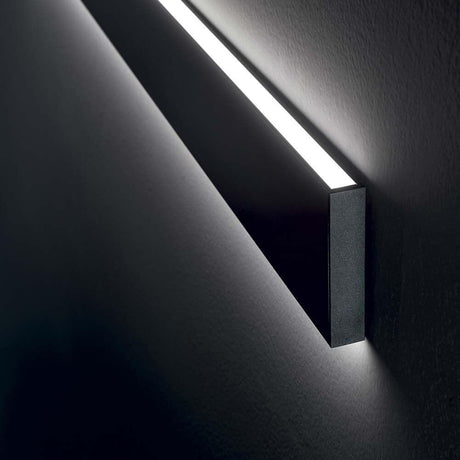Linus LED Væglampe 120cm på væggen, moderne design med varmt lys, ideel til stilfuld belysning.