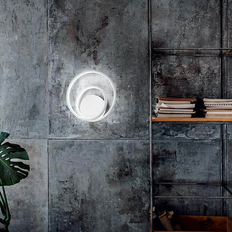 Applique murale Oz LED au design moderne sur un mur en béton avec étagères et plante.