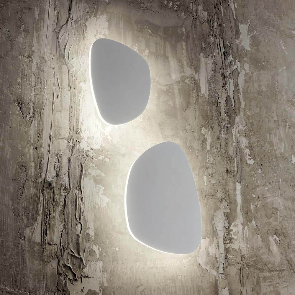 Peggy LED Wandlampe Weiß auf einer strukturierten Wand, modernes Design mit weich ausgeleuchtetem Hintergrund.