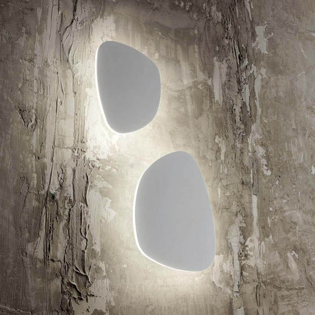 Peggy LED Wandlampe Weiß auf einer strukturierten Wand, modernes Design mit weich ausgeleuchtetem Hintergrund.