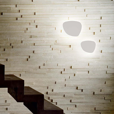 Peggy LED Wandlampe Weiß an einer stilvollen Wand mit Treppe im Hintergrund
