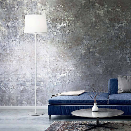 Stylische Set Up Stehleuchte neben einem blauen Sofa in modernem Wohnzimmer mit grauer Wand.