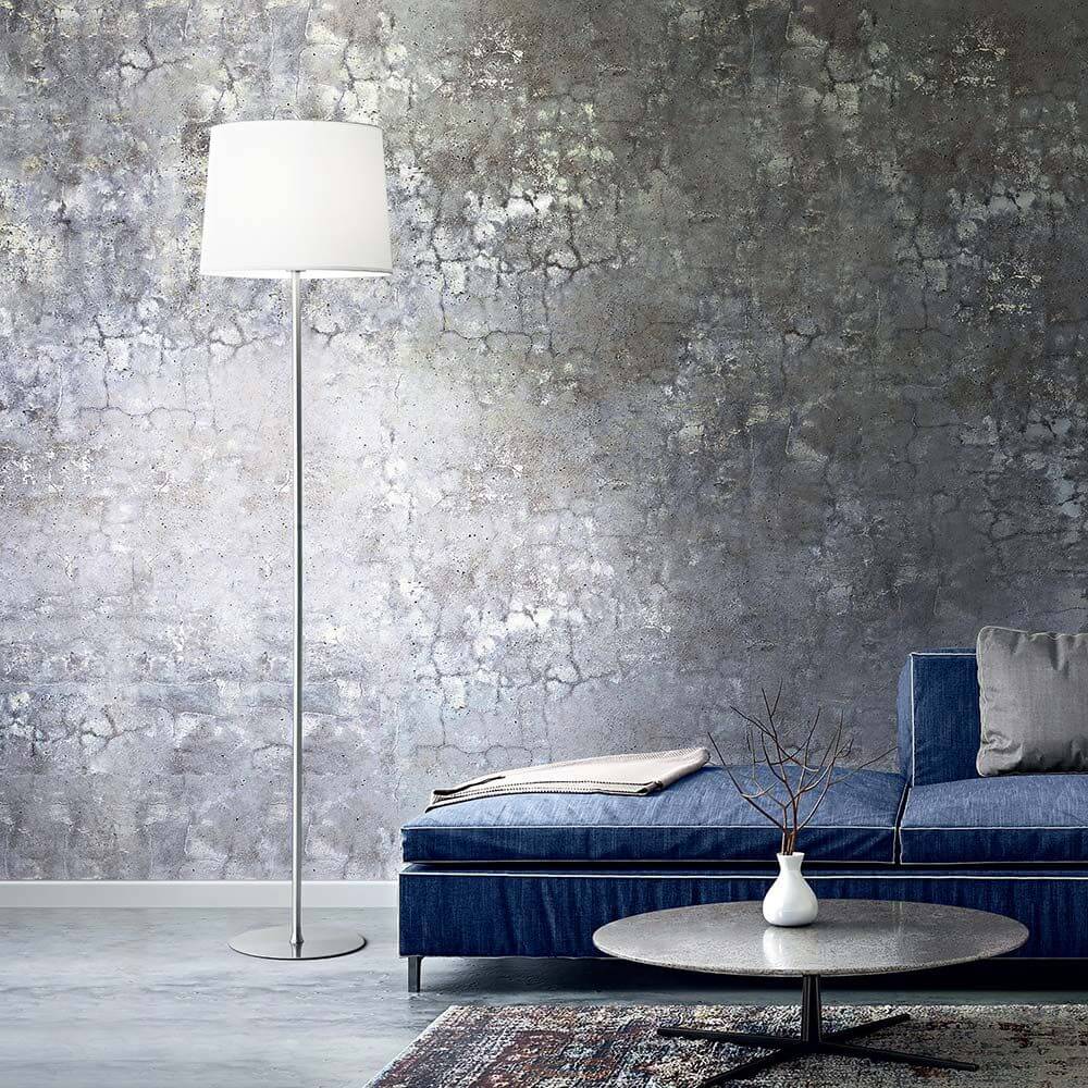 Stylische Set Up Stehleuchte neben einem blauen Sofa in modernem Wohnzimmer mit grauer Wand.