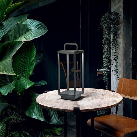 Stardust LED lampe de table à batterie IP54 sur une table entre des plantes dans une pièce élégante.