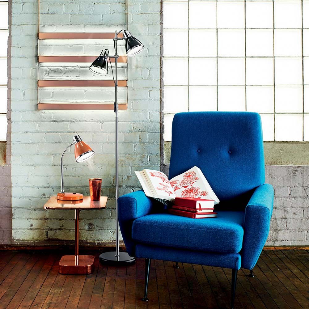 Stehleuchte Elvis Pt2 Schwarz neben einem blauen Sessel und einem Tisch in einem modernen Raum.