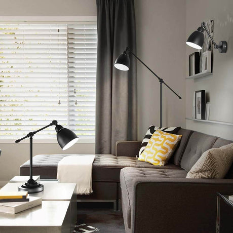 Salon moderne avec lampadaire Newton Pt1 noir et canapé, décoré de manière élégante et stylée.